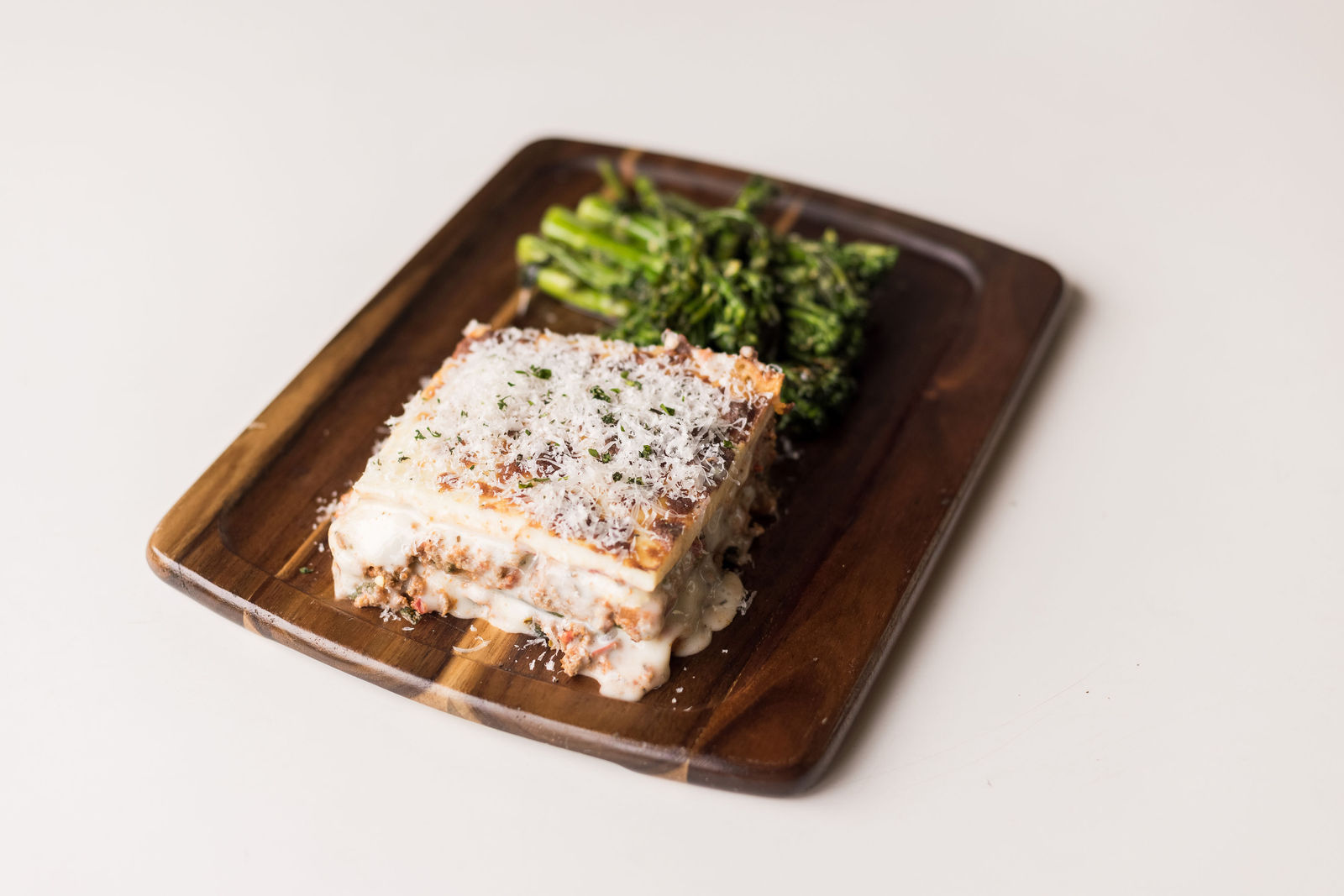 The Italian board: lasagna with charred garlic-herb broccolini on a wood board