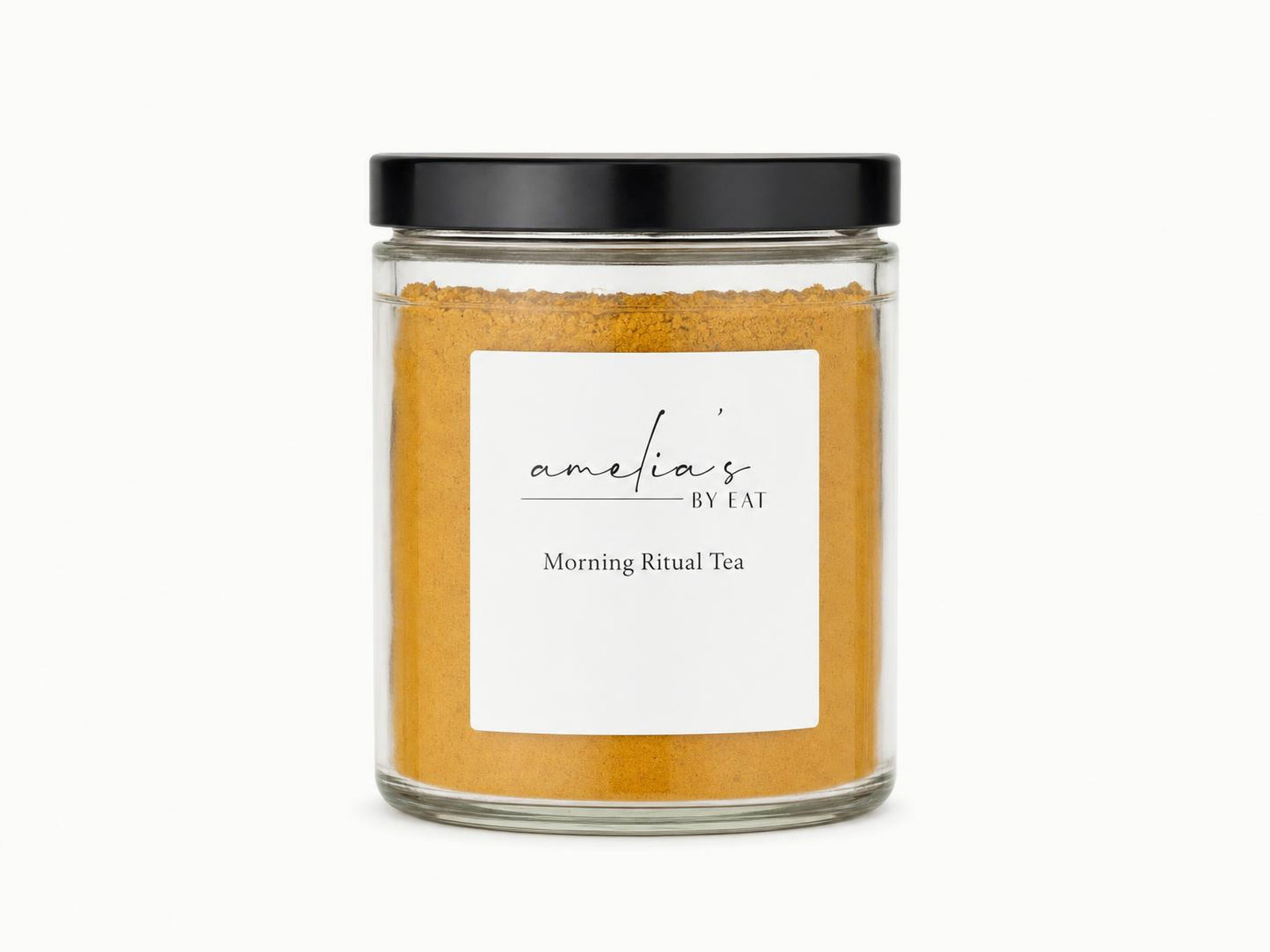 A clear glass jar of golden turmeric Morning Ritual Tea powder with a black lid, on a white background