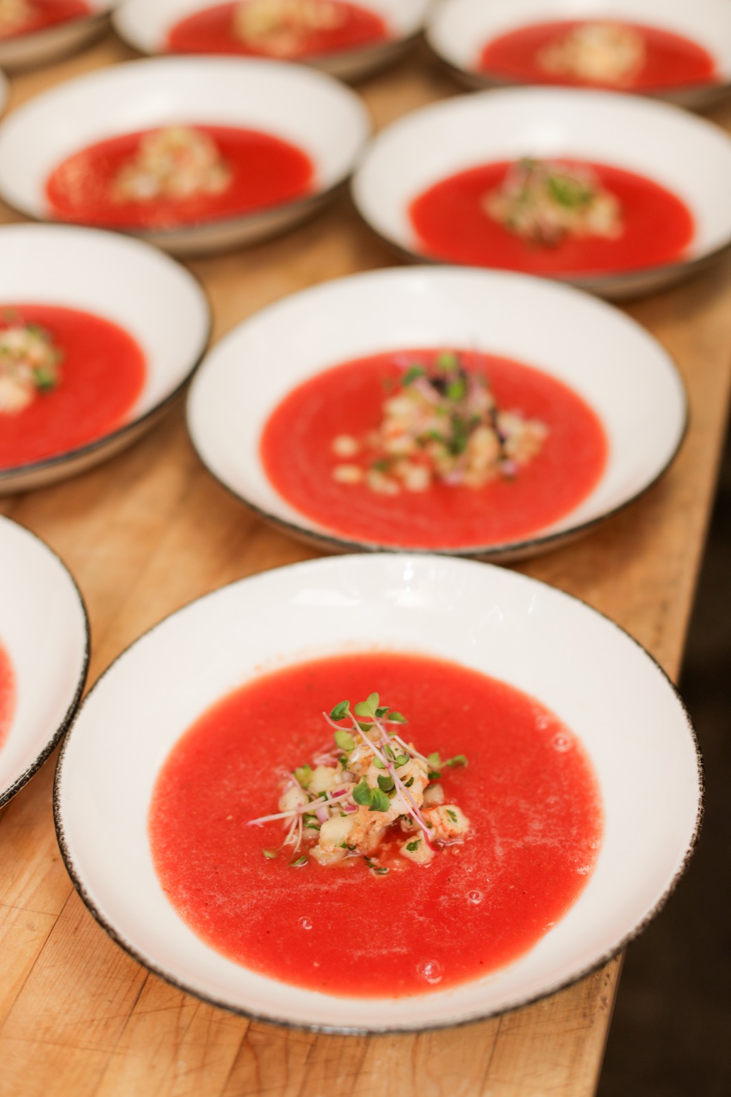 Bowls of chilled tomato soup set out down the length of the table