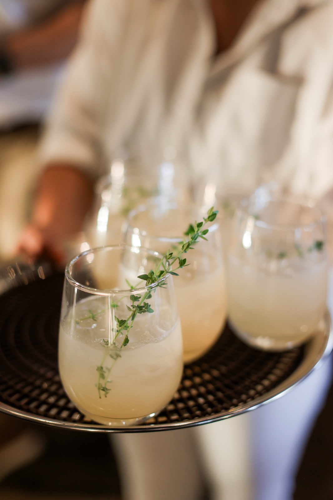 A tray of cocktails garnished with fresh herbs, ready to go out