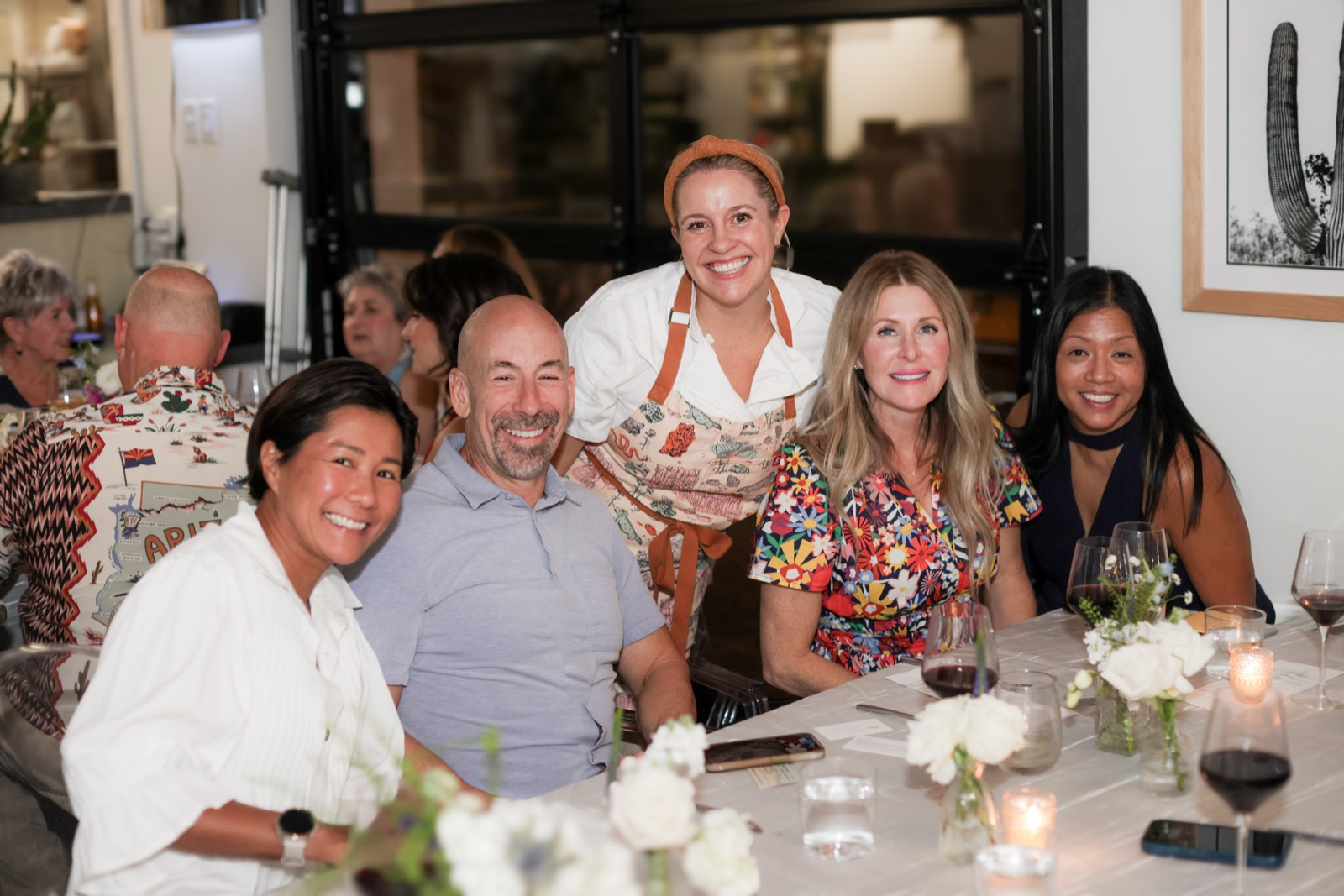 Guests gathered along one long table, glasses poured, mid conversation