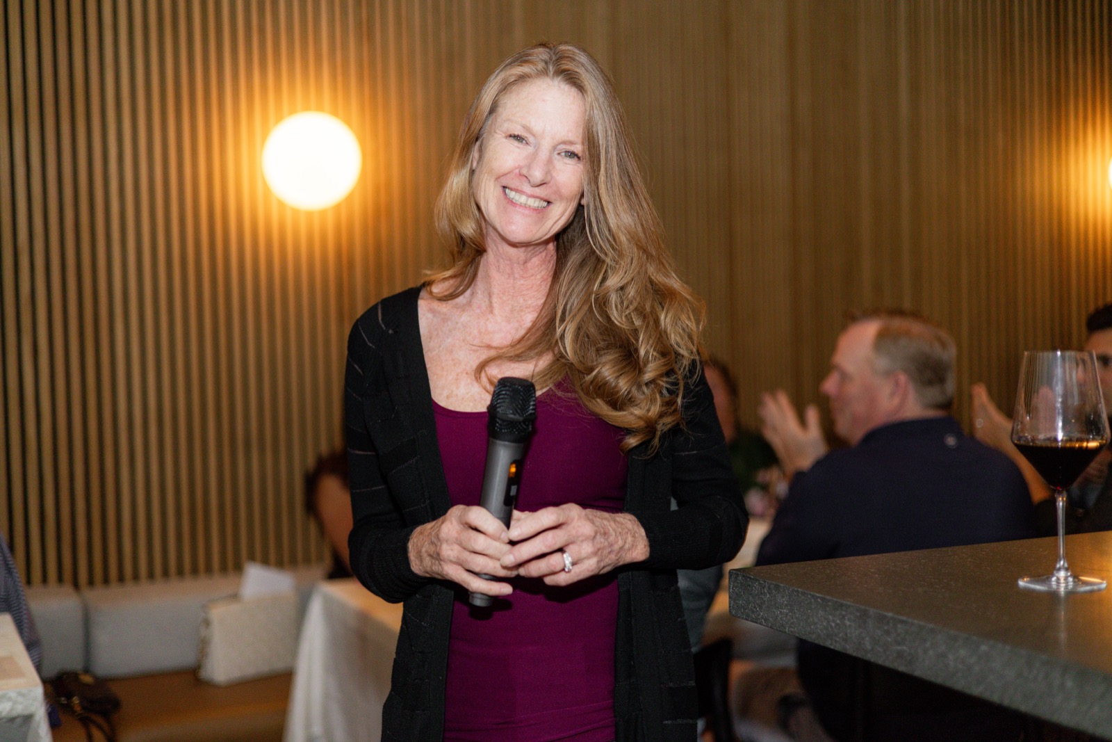 A guest speaking to the room with a microphone between courses