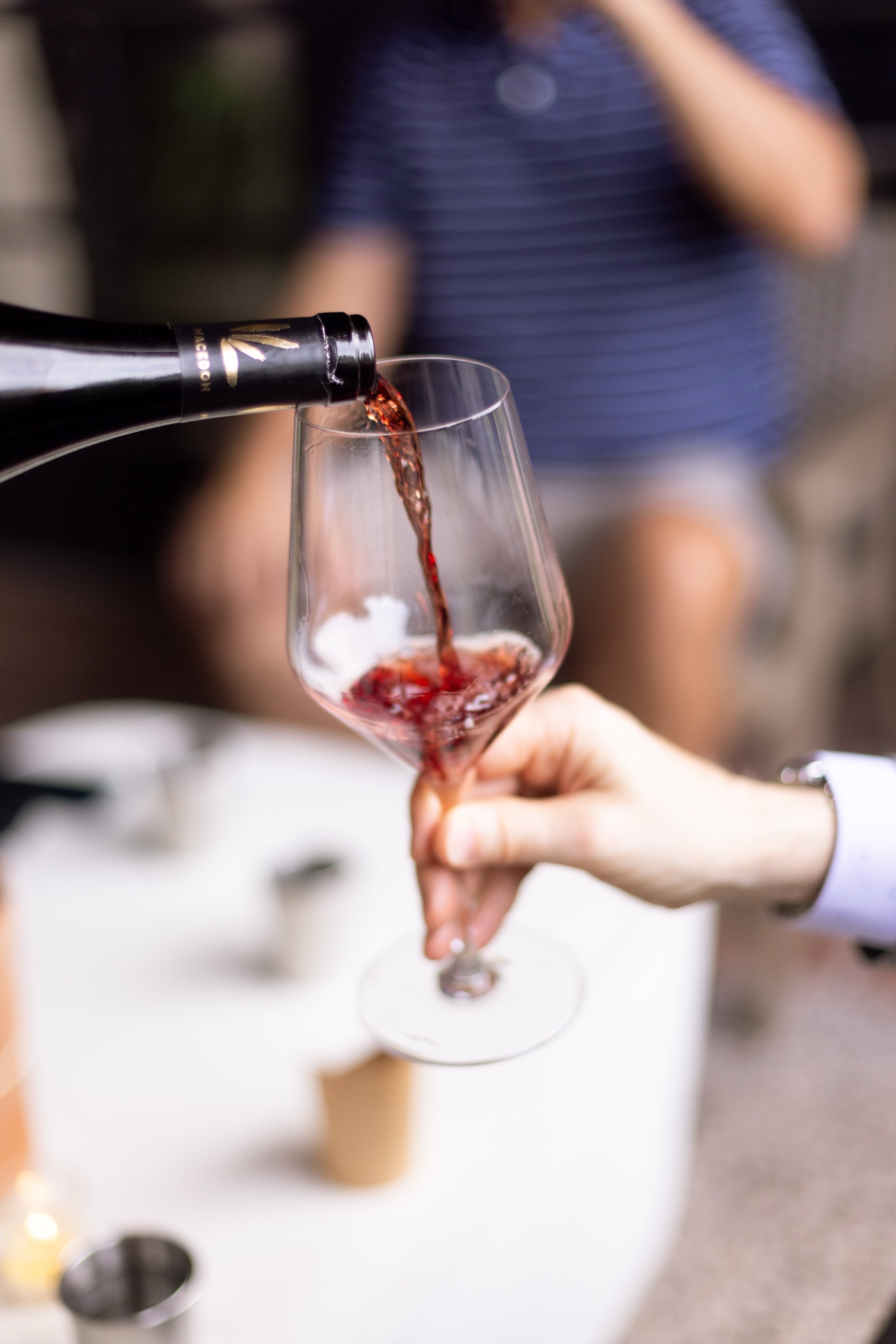 A glass of red wine being poured at Amelia's
