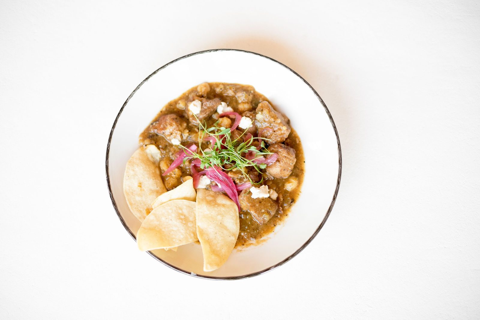 Green Chili Pork Stew — crows dairy goatija, pickled onions, cilantro, house made corn chips | *add egg 3
